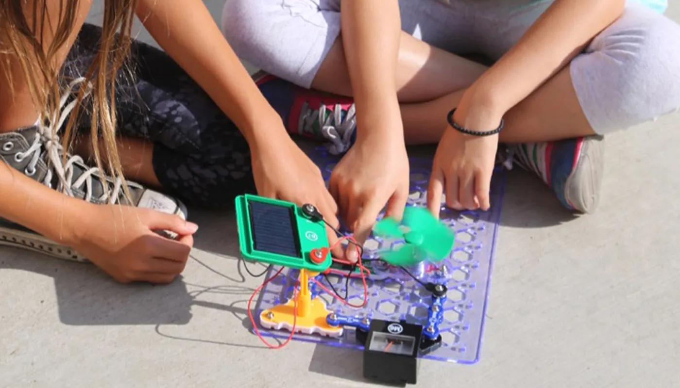 Students collaborating around a hands-on electronics and engineering activity.