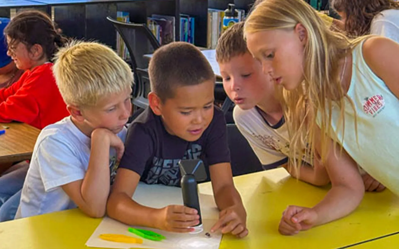 Students examining specialized STEM equipment together during a BrainStorm program.