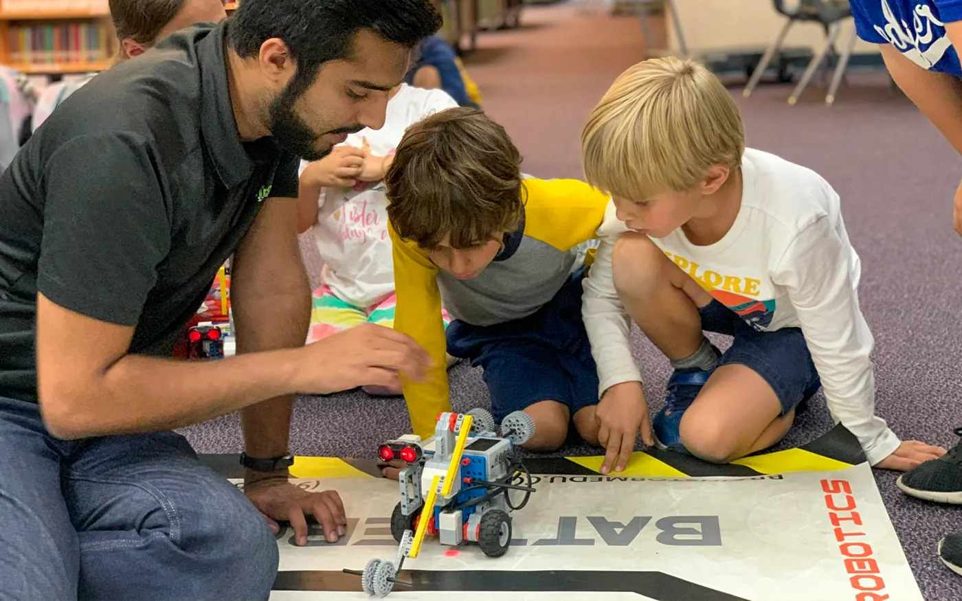 A BrainStorm instructor guiding students through a hands-on robotics activity.