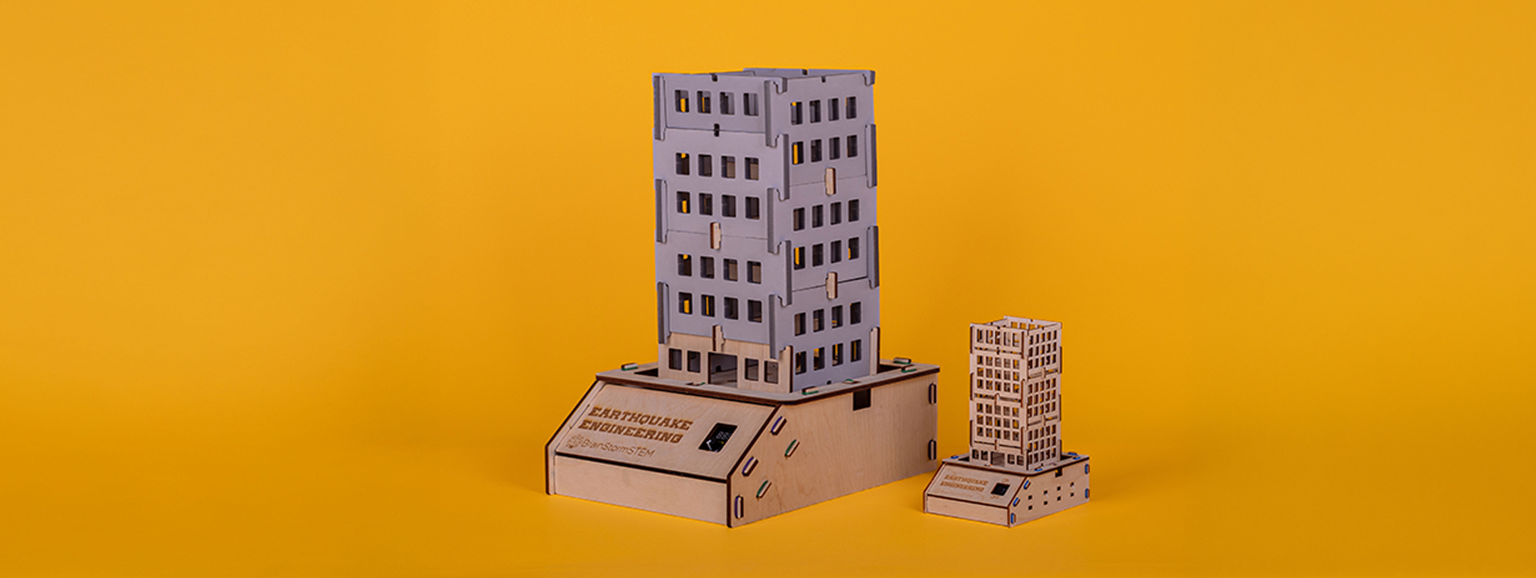 A GIANT earthquake engineering tower model shown beside its smaller classroom-sized version on an orange background.